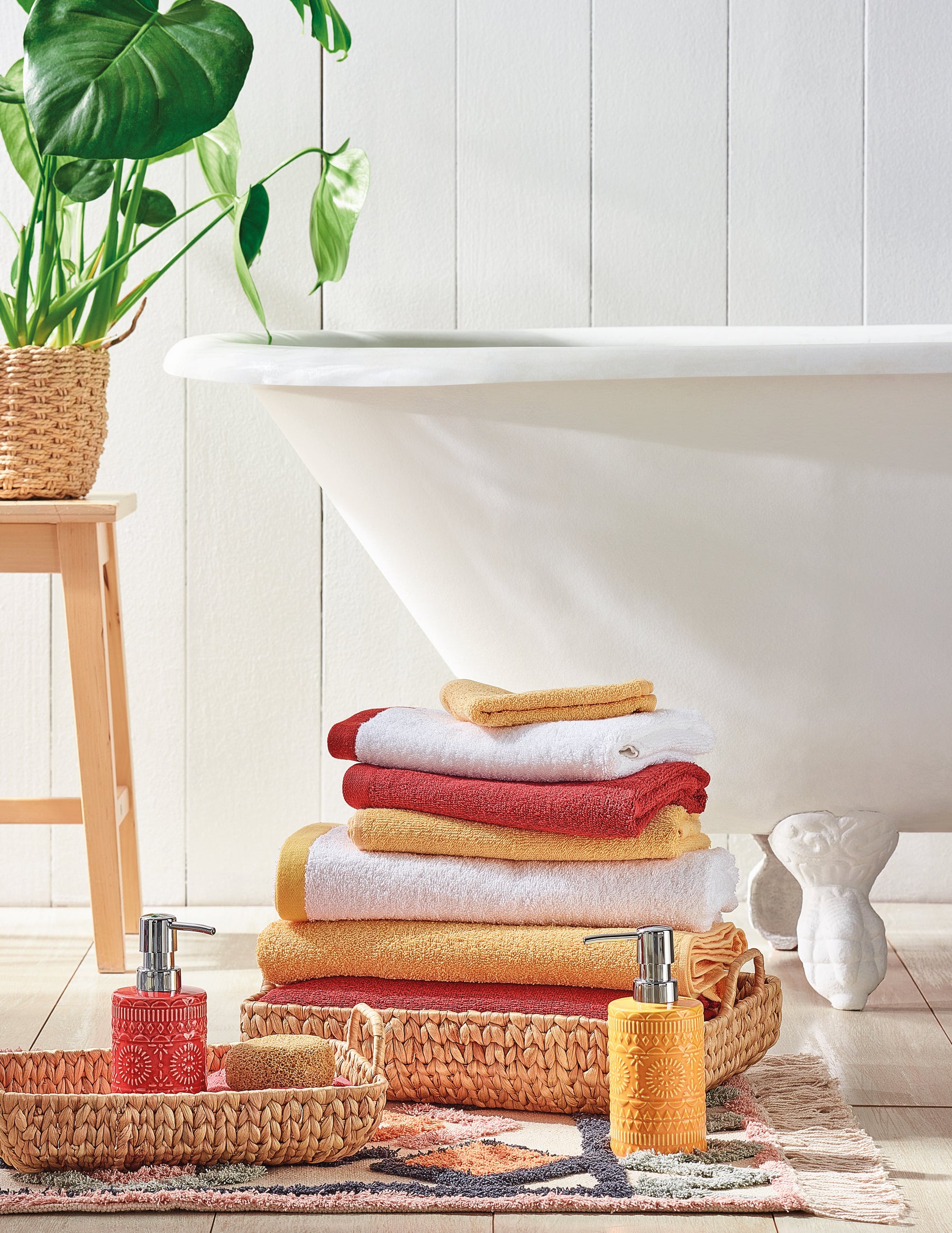 Casa de Banho, com toalhas vermelhas, amarelas, cestos de decoração, saboneteiras e banheiras.