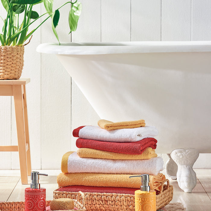 Casa de Banho, com toalhas vermelhas, amarelas, cestos de decoração, saboneteiras e banheiras.