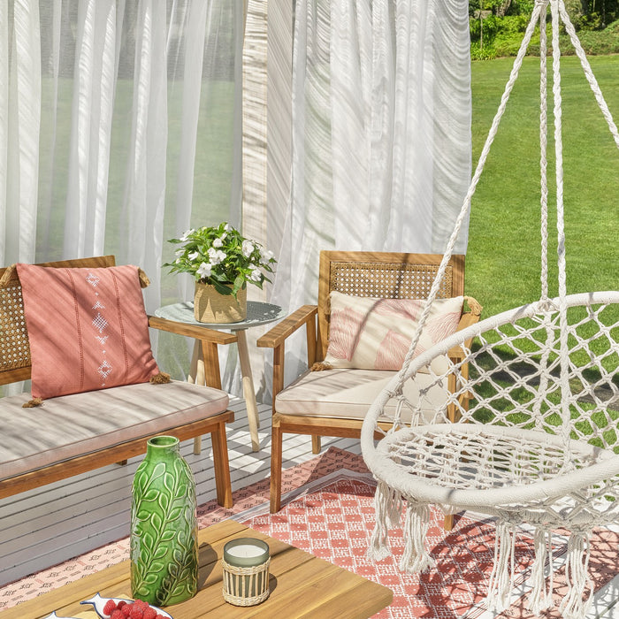 Imagem de terraço com pérgola branca, conjunto de estar com sofá e cadeiras decorado com almofadas e um baloiço pendurado no teto.